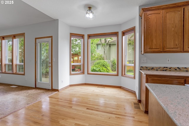 17811 NW Gilbert Ln, Portland, OR 97229 - unfurnished dining area with light wood-type flooring, plenty of natural light, and baseboards