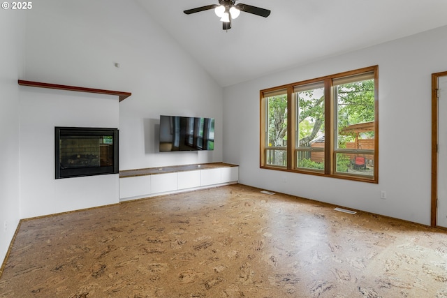17811 NW Gilbert Ln, Portland, OR 97229 - unfurnished living room featuring a ceiling fan, a glass covered fireplace, and high vaulted ceiling