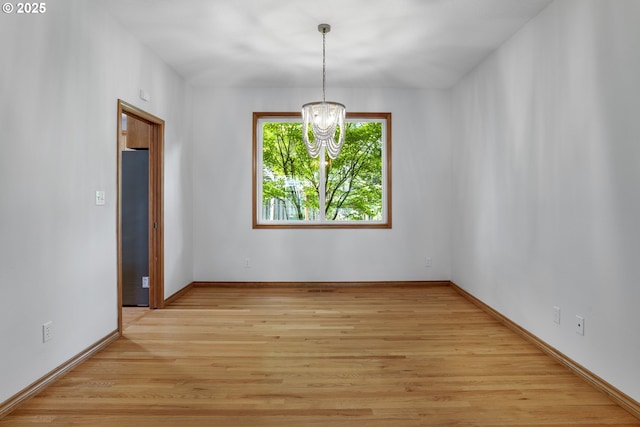 17811 NW Gilbert Ln, Portland, OR 97229 - unfurnished room featuring a chandelier, light wood-style flooring, and baseboards