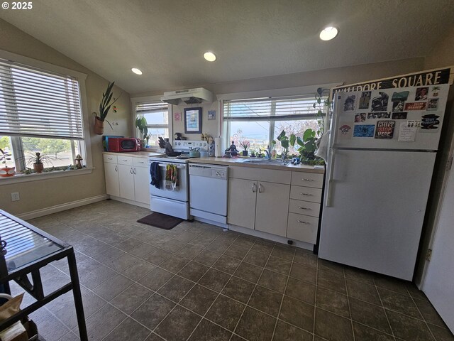 110 2nd St, Astoria, OR 97103 - kitchen featuring white appliances, under cabinet range hood, white cabinetry, a sink, and vaulted ceiling