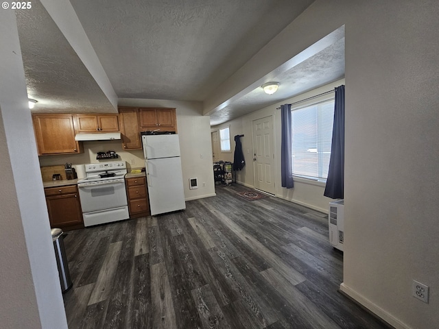 110 2nd St, Astoria, OR 97103 - kitchen featuring white appliances, under cabinet range hood, a textured ceiling, dark wood-type flooring, and baseboards