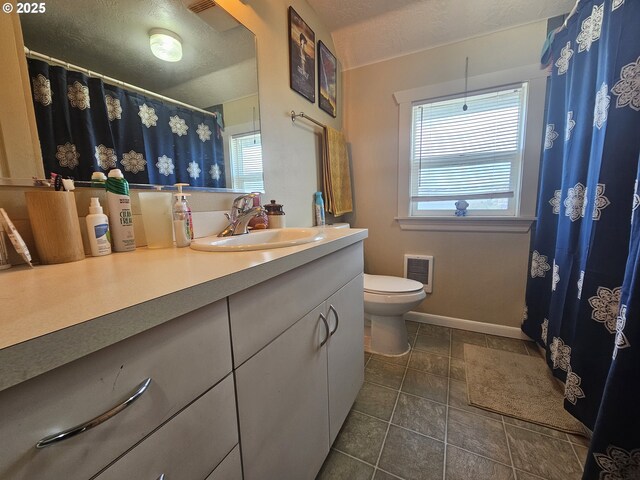 110 2nd St, Astoria, OR 97103 - full bath with toilet, vanity, baseboards, a textured ceiling, and tile patterned floors