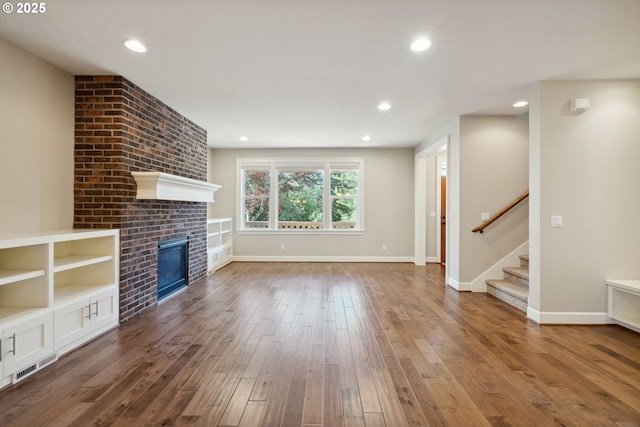 2760 SW Sylvania Ter, Portland, OR 97219 - unfurnished living room with hardwood / wood-style floors, stairway, a fireplace, and recessed lighting