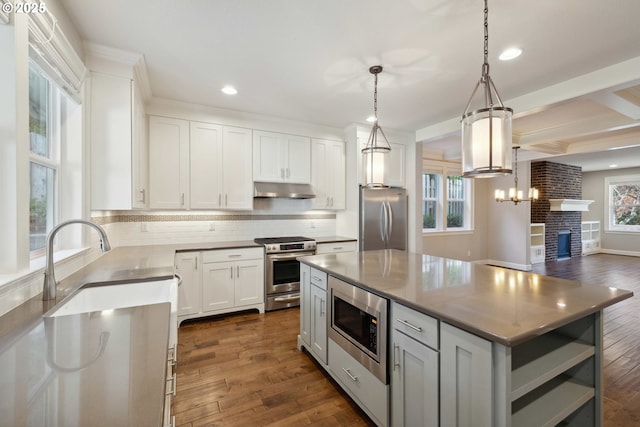2760 SW Sylvania Ter, Portland, OR 97219 - kitchen with stainless steel appliances, under cabinet range hood, plenty of natural light, dark wood finished floors, and recessed lighting