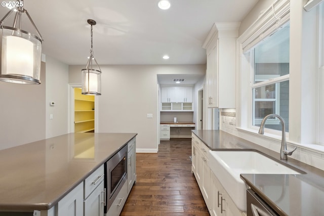 2760 SW Sylvania Ter, Portland, OR 97219 - kitchen with stainless steel microwave, dark wood-style floors, recessed lighting, white cabinets, and decorative light fixtures