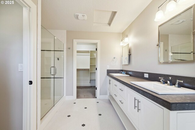 2760 SW Sylvania Ter, Portland, OR 97219 - full bath featuring a shower stall, double vanity, a walk in closet, and tile patterned flooring