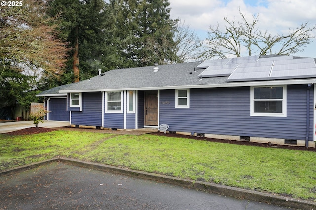 view of front of house with solar panels, a front lawn, and a garage