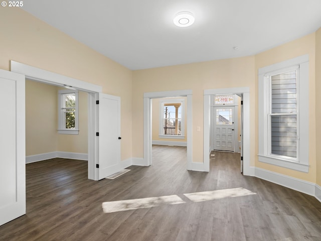 interior space with baseboards, a wealth of natural light, and wood finished floors