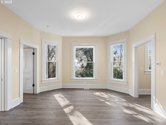 unfurnished dining area featuring baseboards and wood finished floors