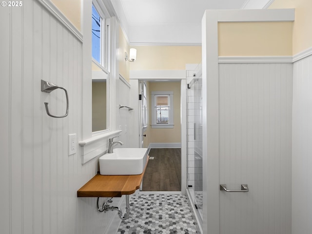 full bathroom featuring ornamental molding, tile patterned flooring, a sink, and a shower stall