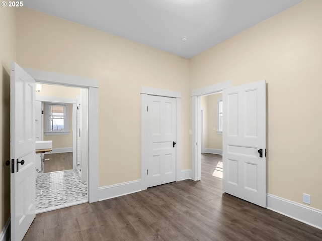 unfurnished bedroom featuring dark wood-style flooring and baseboards