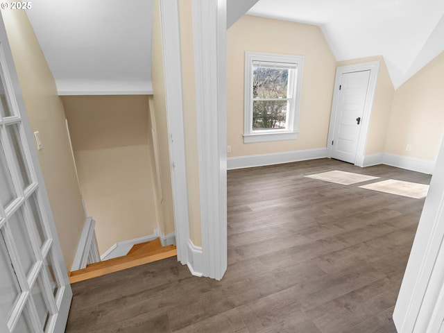 additional living space with lofted ceiling, baseboards, and wood finished floors