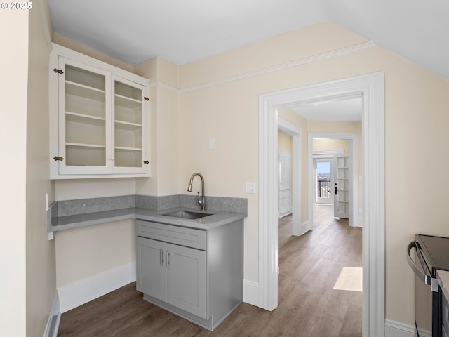 bar with range with electric cooktop, dark wood-style flooring, a sink, and baseboards