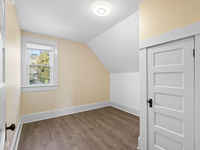 additional living space with vaulted ceiling, baseboards, and wood finished floors