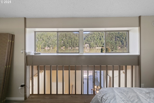 43605 State Highway 38 Unit 9, Reedsport, OR 97467 - bedroom with multiple windows, a textured ceiling, and wood finished floors