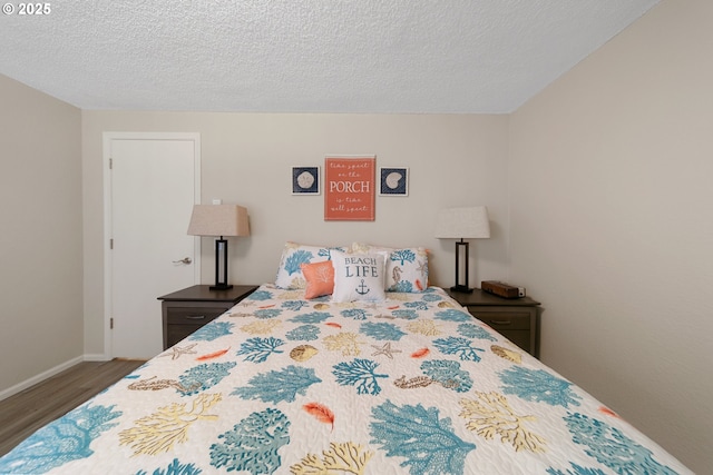 43605 State Highway 38 Unit 9, Reedsport, OR 97467 - bedroom featuring wood finished floors, baseboards, and a textured ceiling