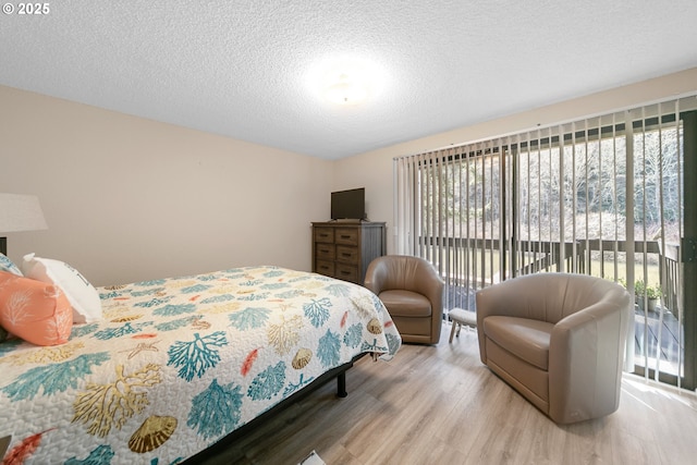 43605 State Highway 38 Unit 9, Reedsport, OR 97467 - bedroom with access to exterior, wood finished floors, and a textured ceiling