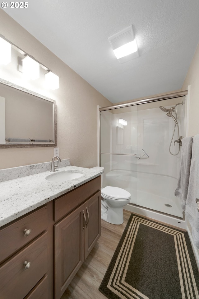 43605 State Highway 38 Unit 9, Reedsport, OR 97467 - bathroom with wood finished floors, a shower stall, vanity, and toilet