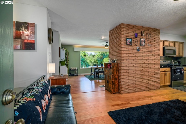 7360 SE Imperial Ct, Milwaukie, OR 97222 - living room with light wood finished floors, ceiling fan, and a textured ceiling