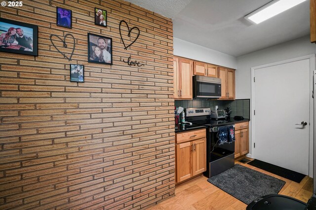 7360 SE Imperial Ct, Milwaukie, OR 97222 - kitchen with stainless steel electric range oven, dark countertops, light wood-style flooring, and tasteful backsplash
