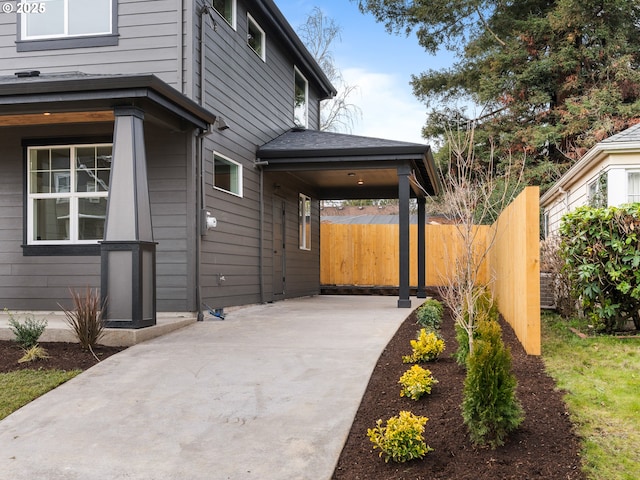 exterior space featuring a patio area, fence, and concrete driveway