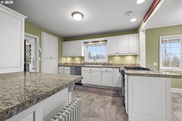 kitchen with stainless steel appliances, recessed lighting, white cabinets, and a sink