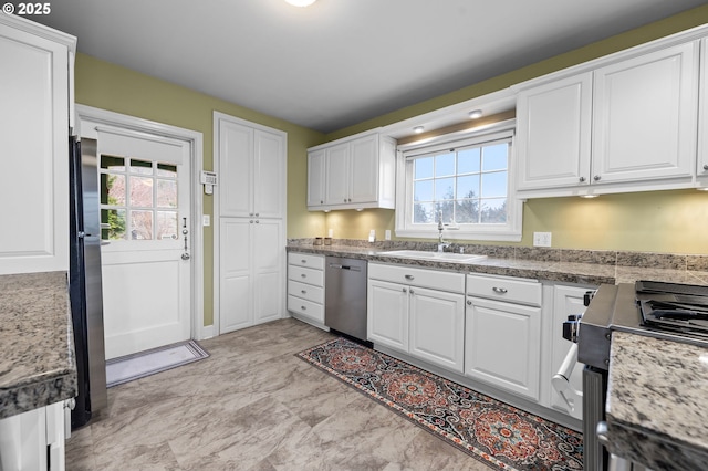 kitchen with appliances with stainless steel finishes, white cabinets, and a sink