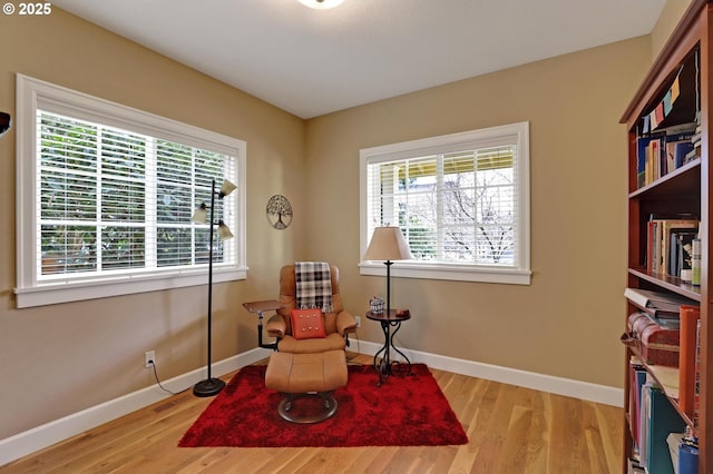 sitting room featuring a wealth of natural light, baseboards, and wood finished floors