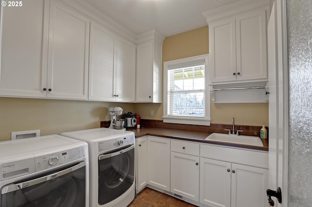 laundry room featuring washer and dryer, cabinet space, and a sink