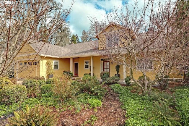 view of front of house with a garage and a shingled roof