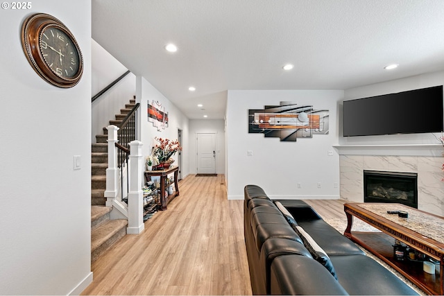 2504 Brackenfern Rd, Eugene, OR 97403 - living area featuring light wood-style flooring, a premium fireplace, stairway, recessed lighting, and baseboards