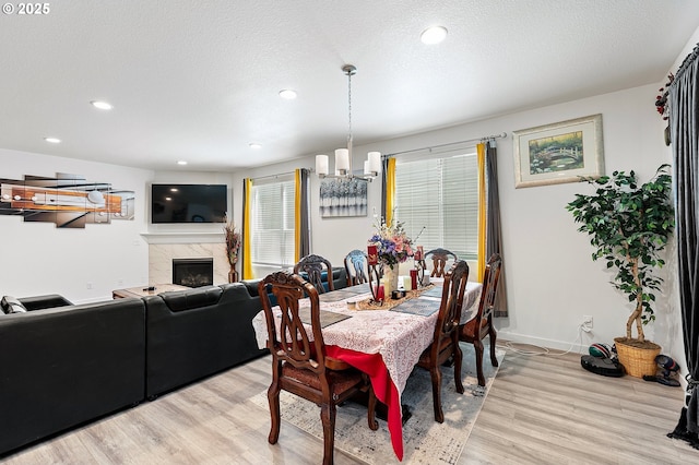 2504 Brackenfern Rd, Eugene, OR 97403 - dining space with light wood finished floors, a premium fireplace, recessed lighting, baseboards, and a chandelier