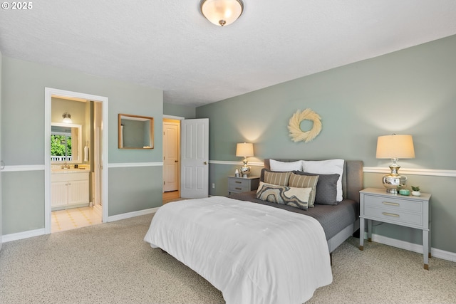6025 SW Spruce Ave, Beaverton, OR 97005 - bedroom with baseboards, ensuite bathroom, a sink, and a textured ceiling
