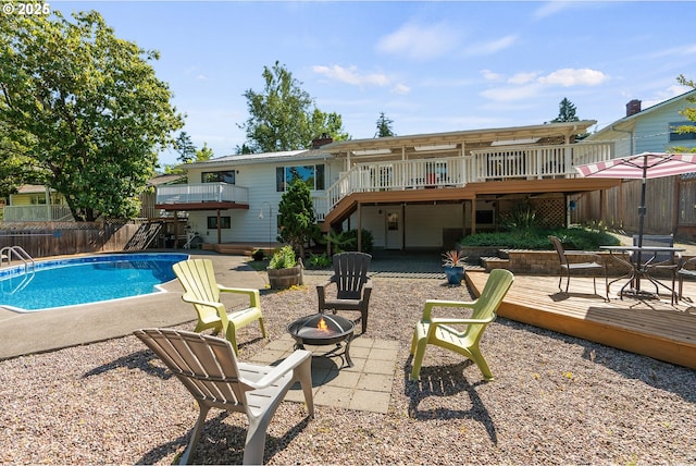 6025 SW Spruce Ave, Beaverton, OR 97005 - back of property with stairs, a wooden deck, a fire pit, and a patio
