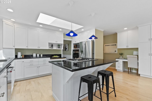 6025 SW Spruce Ave, Beaverton, OR 97005 - kitchen with stainless steel appliances, light wood-style flooring, white cabinets, a skylight, and recessed lighting