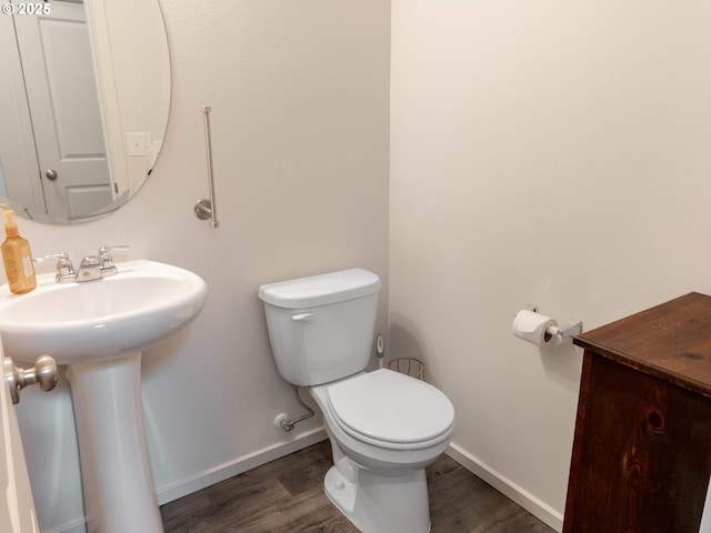 bathroom with wood-type flooring, toilet, and sink