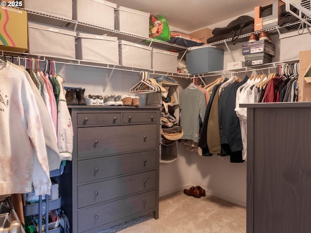 walk in closet featuring light carpet