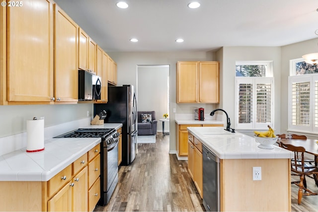 kitchen featuring tile countertops, light brown cabinets, stainless steel appliances, and a wealth of natural light