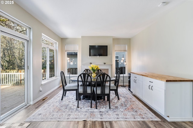 dining room with light wood-style flooring, visible vents, and baseboards