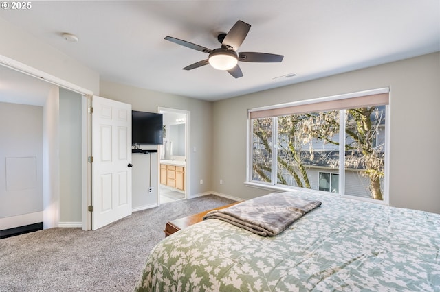 bedroom featuring ensuite bathroom, carpet floors, visible vents, and baseboards