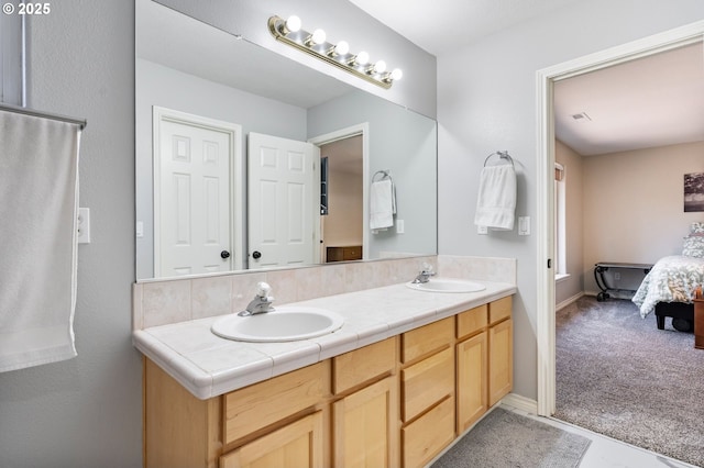 bathroom featuring double vanity, ensuite bath, a sink, and visible vents