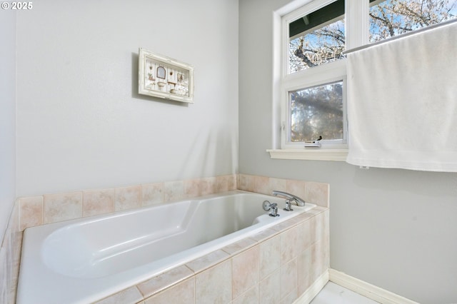 full bath featuring baseboards and a bath