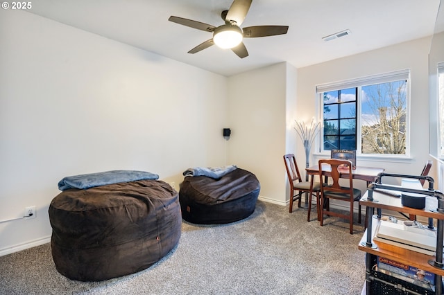 sitting room with carpet floors, baseboards, visible vents, and a ceiling fan