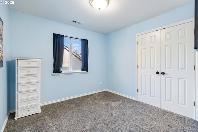 unfurnished bedroom with a closet, carpet flooring, visible vents, and baseboards