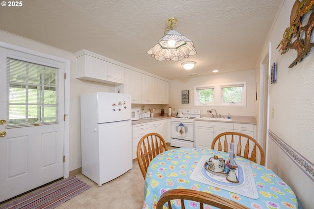 kitchen featuring white cabinetry, white appliances, light countertops, and a sink