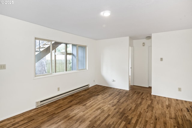 empty room with baseboard heating, baseboards, and wood finished floors