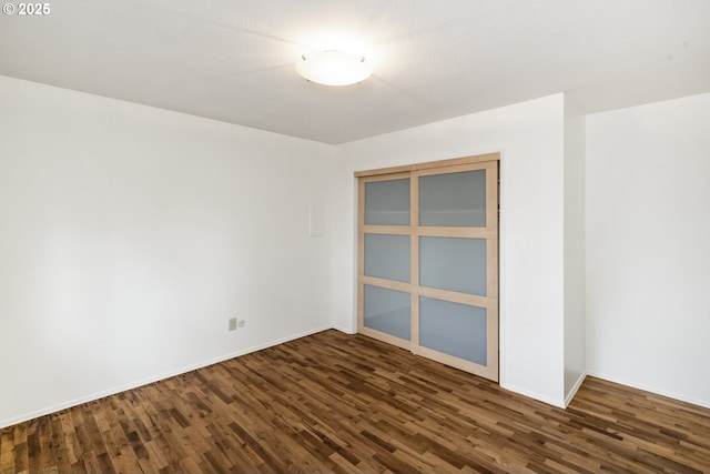 spare room with wood finished floors and baseboards