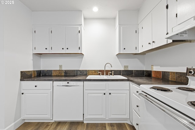 kitchen with white appliances, a sink, white cabinets, under cabinet range hood, and dark countertops