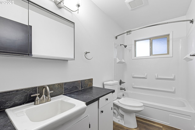 bathroom featuring visible vents, toilet, shower / bathtub combination, wood finished floors, and vanity