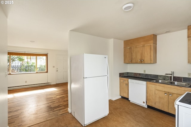 kitchen featuring white appliances, wood finished floors, a baseboard radiator, a sink, and dark countertops